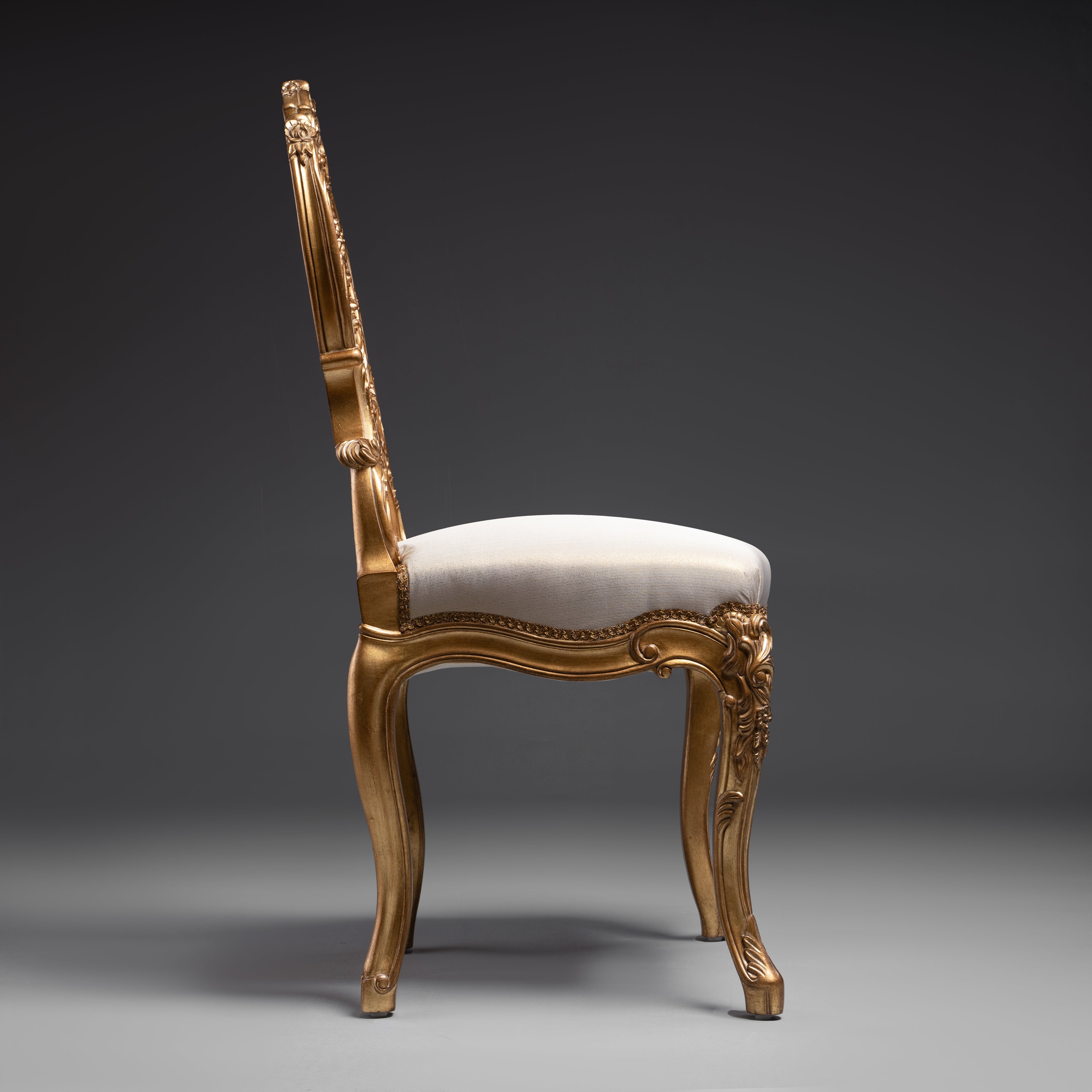 A masterpiece of baroque artistry, this gilded  chair features an intricately carved backrest  with opulent detailing.