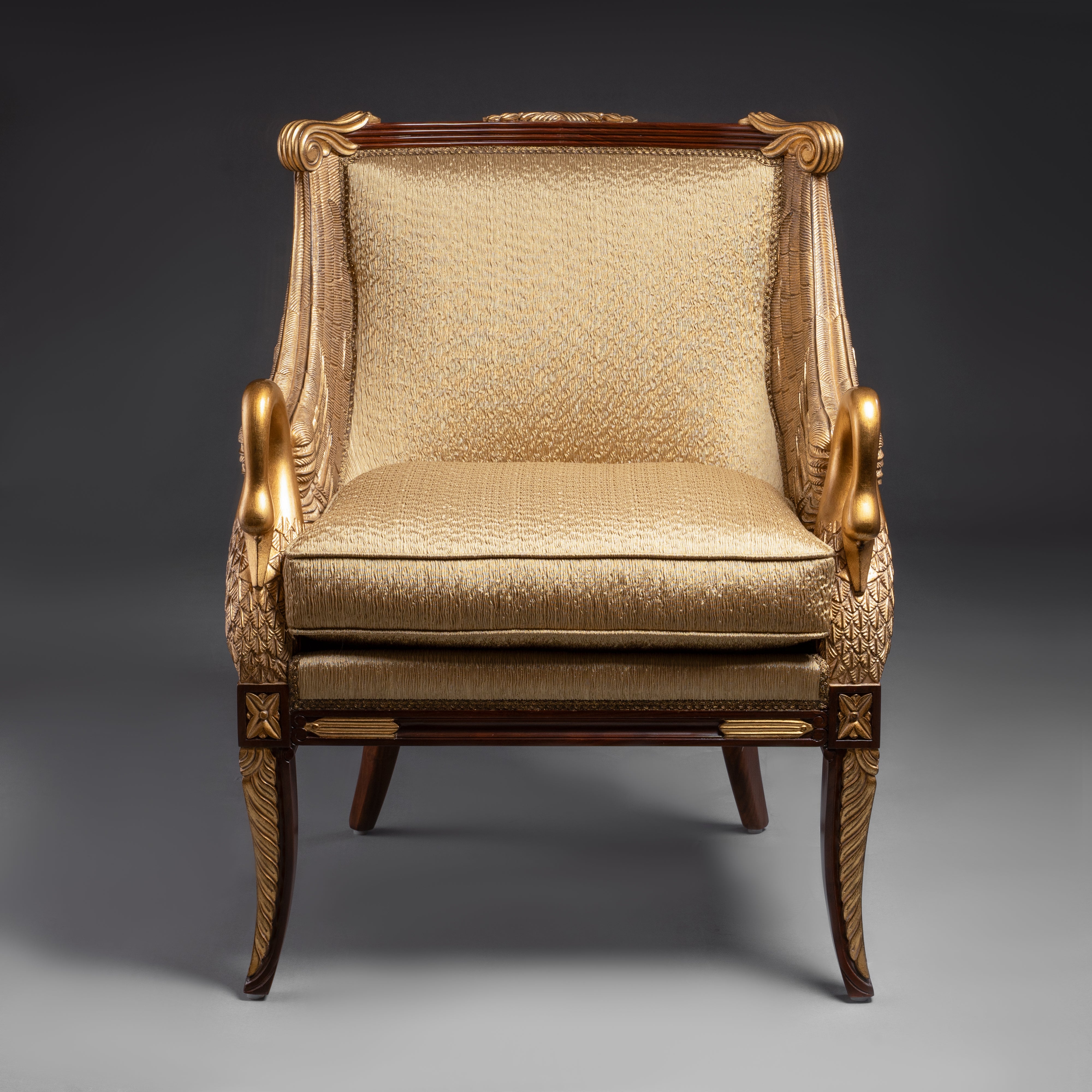 A regal Empire-style armchair featuring  exquisitely carved and gilded swan motifs,  embodying timeless elegance.