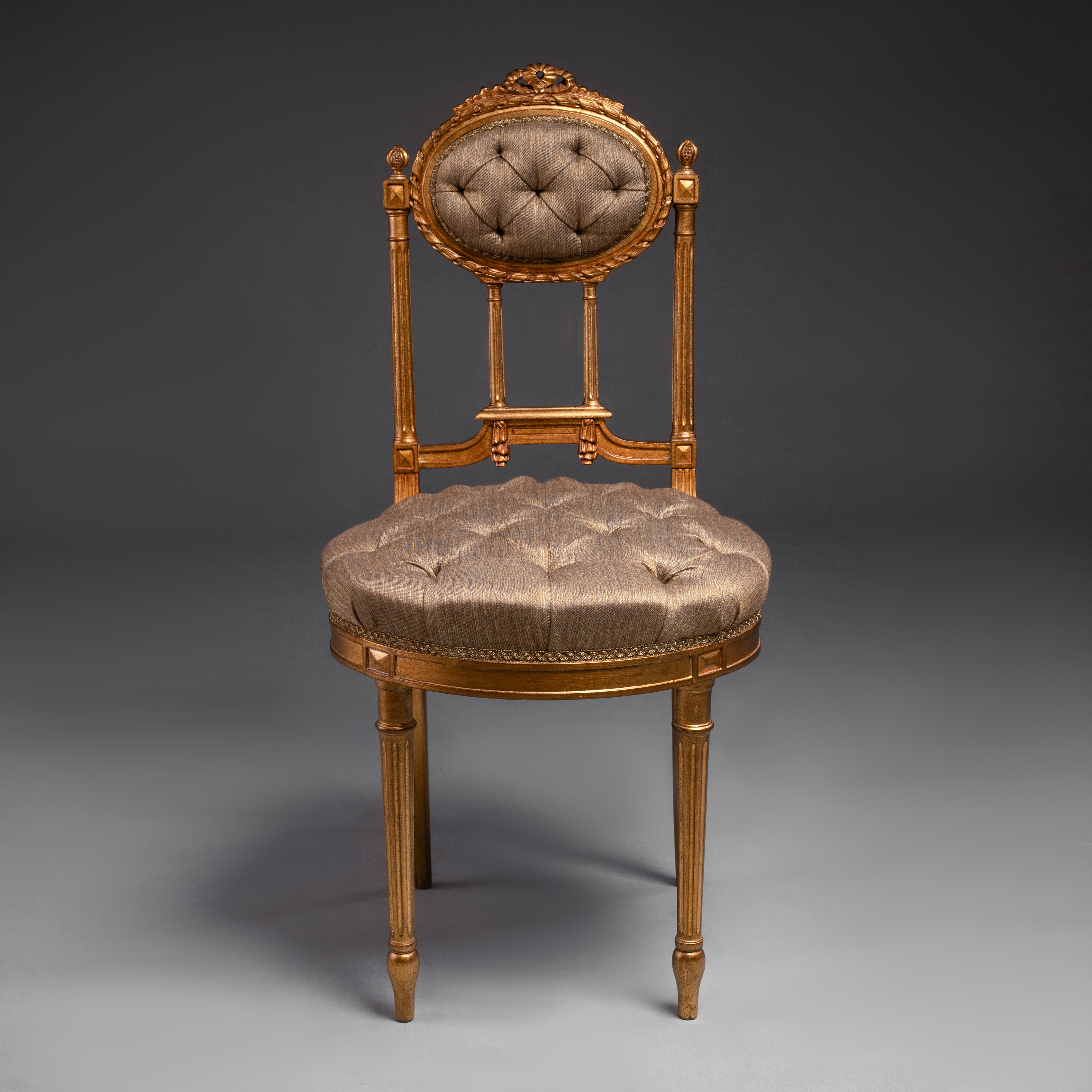 Opulent tufted chair with gilded accents and  regal charm.