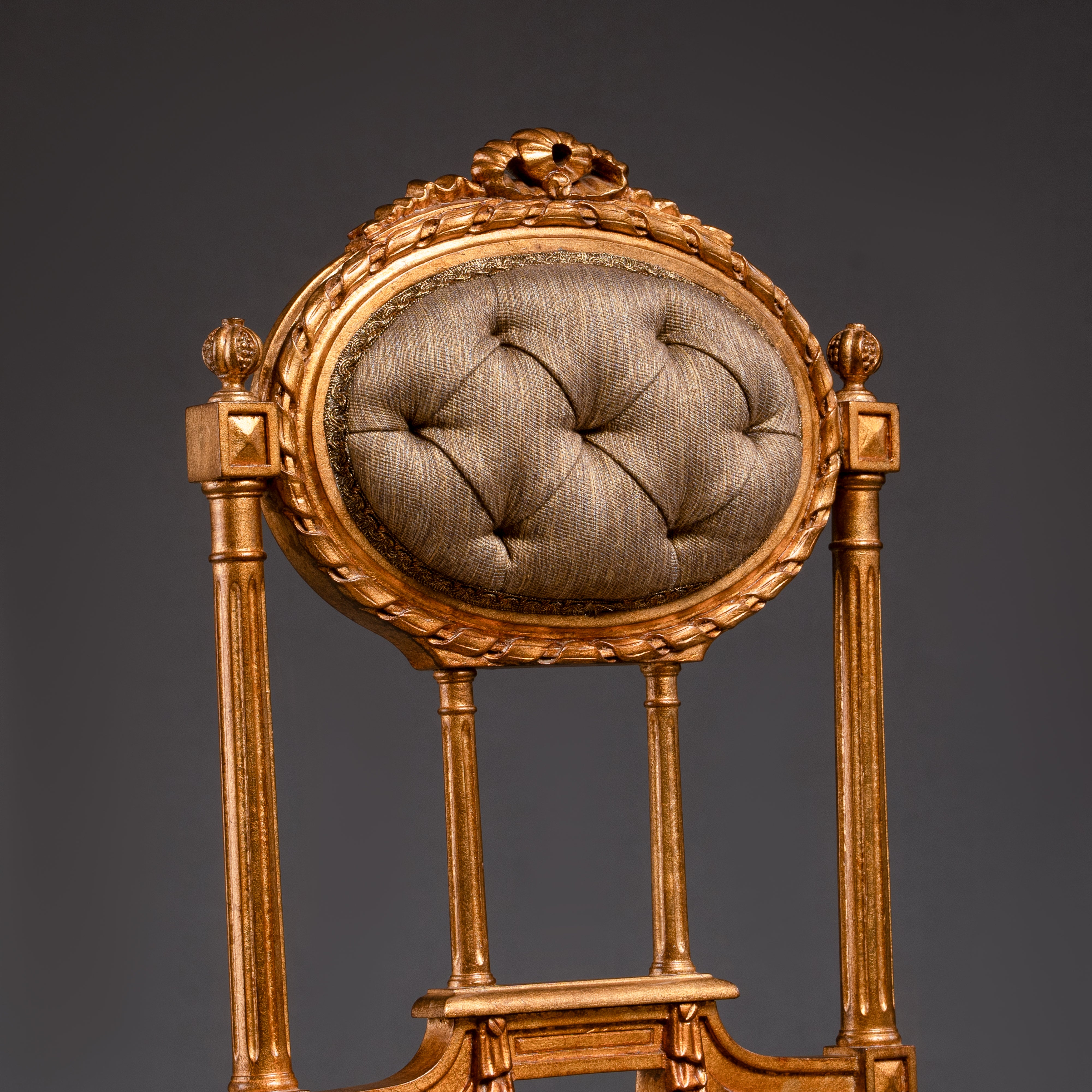 Opulent tufted chair with gilded accents and  regal charm.